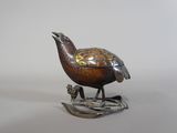 une image représentant un oiseau en bronze perché sur une branche, avec un autre oiseau perché sur son dos