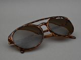 sunglasses on a gray surface with a pair of glasses on top of it