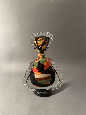 une petite figurine représentant une femme vêtue d'une robe colorée
