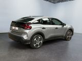 the rear end of a silver car in a white room