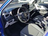 the interior of a blue car with a steering wheel and dashboard