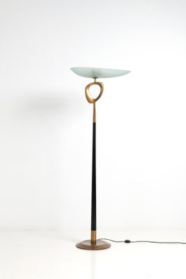 un lampadaire noir et doré surmonté d'un abat-jour en verre