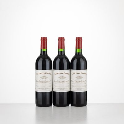 trois bouteilles de vin rouge posées sur une table