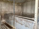 a dirty room with a bunch of stalls inside of it