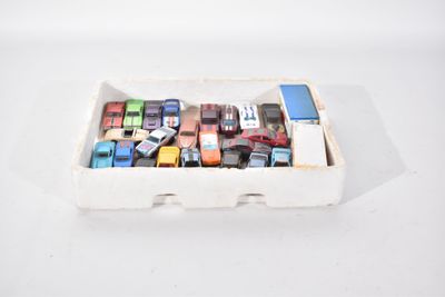 une boîte de petites voitures assorties posée sur une surface blanche
