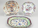 three chinese plates with floral designs on them on a white surface