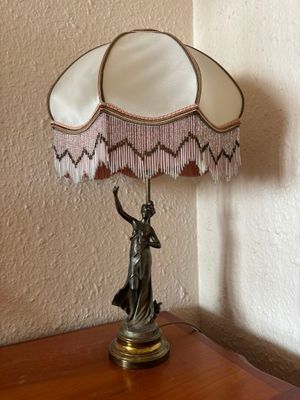 a lamp that is sitting on a table with a lamp shade on it