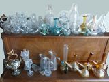 de nombreux vases en verre posés sur une étagère en bois dans une pièce
