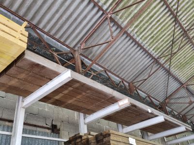 plusieurs piles de bois empilées les unes sur les autres dans un entrepôt