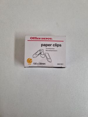 a small box of paper clips on a white surface