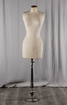 un mannequin vide posé sur un socle devant un fond blanc