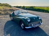 une voiture verte garée sur le bord de la route