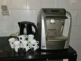a coffee maker and cups on a counter in a kitchen
