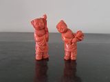 two small figurines of people standing on a table