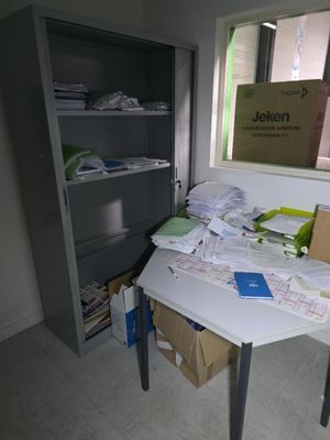un bureau recouvert de papiers, dans une pièce