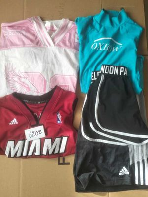 several shirts and shorts laid out in a box on a table
