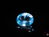 a close up of a blue diamond on a black surface