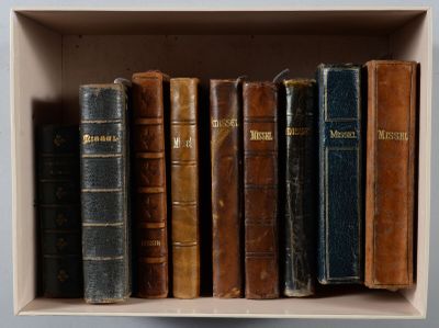 de nombreux livres anciens dans une boîte blanche posée sur une étagère