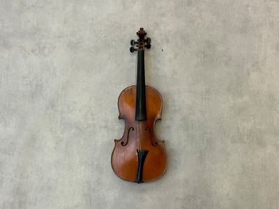 un vieux violon accroché au mur, orné d'une croix