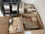 une boîte remplie de livres posée par terre à côté d'une pile de livres
