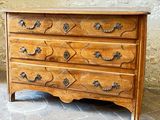 a wooden chest of drawers sitting on a tiled floor