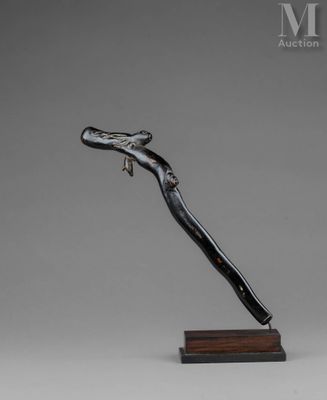 une sculpture en noir et blanc représentant un oiseau, posée sur un socle en bois