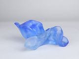 a blue glass flower sitting on a white surface