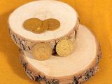 two wooden slices with coins on them on a yellow background