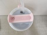 a cup of water with a pink handle on it