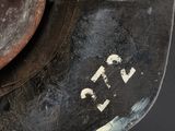 a close up of a rusted metal object on a black surface