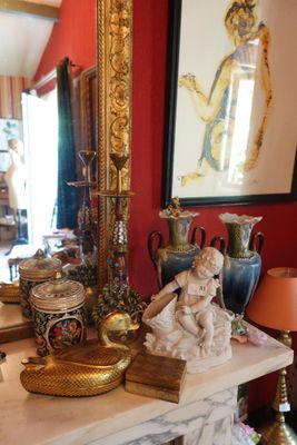 une table sur laquelle se trouvent un miroir, des vases et une statue