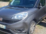 La voiture est garée sur le bord de la route, avec une remorque attelée.