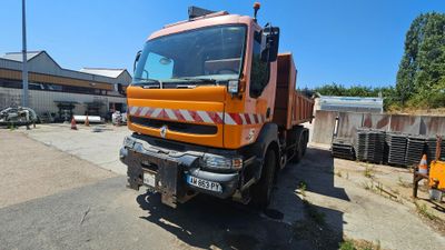 un gros camion orange garé devant un immeuble