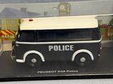 a black and white toy police van in a clear case