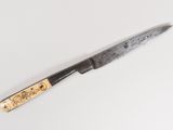 a knife that is laying on a white surface