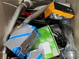 a cardboard box filled with assorted items that include an umbrella, a can of soda, and other items