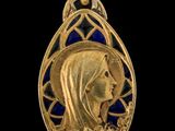 Gros plan sur un pendentif en or orné d'un visage de femme