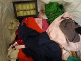 a pile of clothes that is sitting on a bed