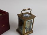 a small clock sitting next to a small box on a table
