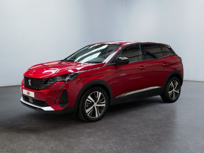 Une voiture rouge est garée dans une pièce aux murs blancs.