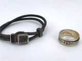 pair of silver and leather bracelets and a ring on a white surface