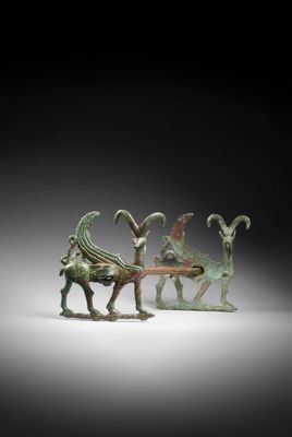 a group of three bronze figurines of animals and a goat