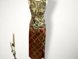 une photo d'une robe posée sur un mannequin, à côté d'un vase de fleurs