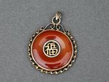un gros plan d'un pendentif orné d'un symbole chinois