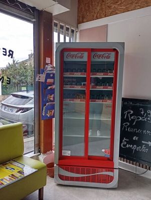 a coca cola machine in the corner of a store