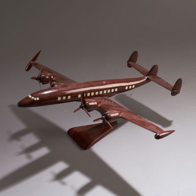 une petite maquette d'avion posée sur une surface blanche