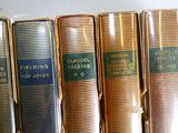 plusieurs vieux livres sont alignés sur une étagère