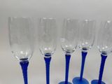 four blue wine glasses sitting next to each other on a table