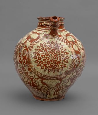 an orange and white vase sitting on top of a gray surface