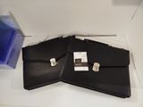 two black leather briefcases sitting on a white table